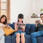 Asian family using tablet and mobile phones at home. addicted to devices, gadgets dependence overuse