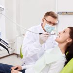 The dentist treats teeth of patient