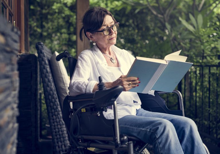 Woman reading a book in a wheelchair